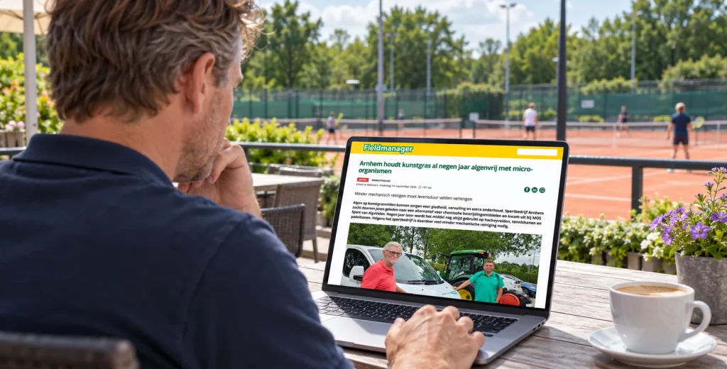 Het Fieldmanager-artikel over Sportbedrijf Arnhem op een laptop bij een sportpark